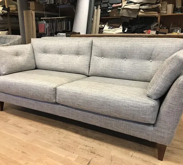 Grå sofa med nytt trekk i verksted