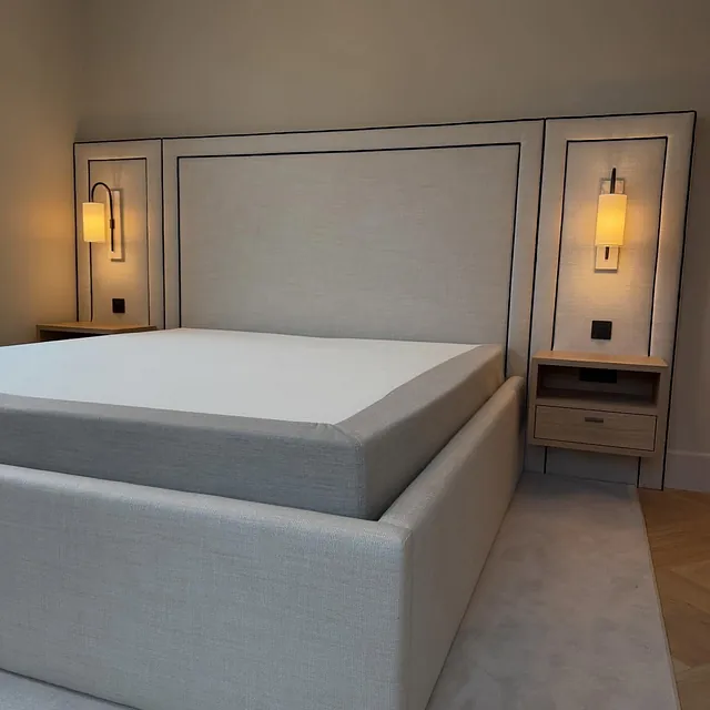 Skreddersydd sengegavl i grått stoff med sorte detaljer