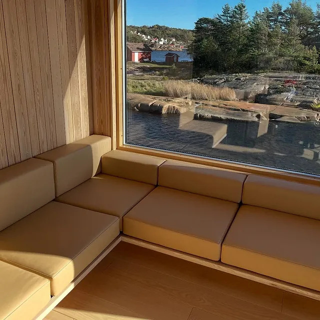 Trukket sofa med utsikt mot hav og naust